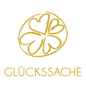 Das goldene Glückssache Logo besteht aus 4 Kleeblättern in einem Kreis